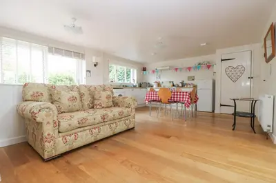 a living room with a couch and a kitchen at Bolitho's Retreat in Saint Martins Green