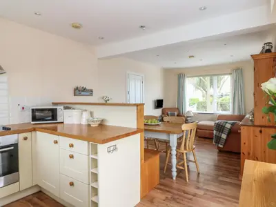 a kitchen and living room with a table and a couch at Bolenowe in Polzeath