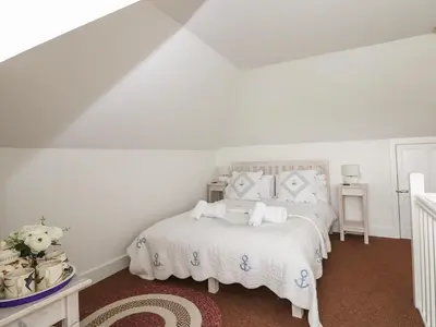 a bedroom with a bed with white sheets and pillows at Bolenowe in Polzeath