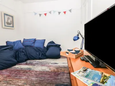 a living room with a bed and a flat screen tv at Bolenowe in Polzeath