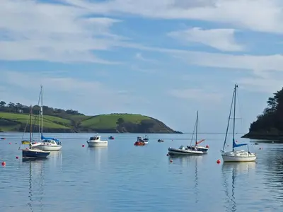 a group of boats floating on a body of water at Pig House, Boskensoe Barns in Helford Passage