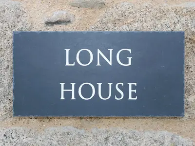 a sign that says long house on a stone wall at Long House, Boskensoe Barns in Helford Passage
