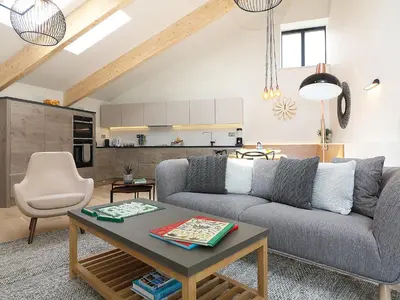 a living room with a couch and a table at Long House, Boskensoe Barns in Helford Passage