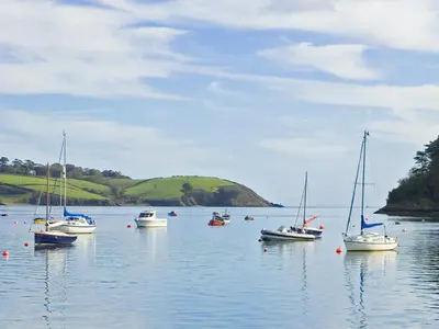 a group of boats floating on a body of water at Long House, Boskensoe Barns in Helford Passage