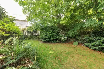 a yard with grass and trees and bushes at Silverwell Forge in Chacewater