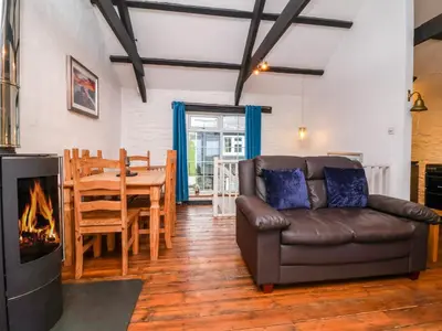 a living room with a couch and a fireplace at Threshings Cottage in Tintagel