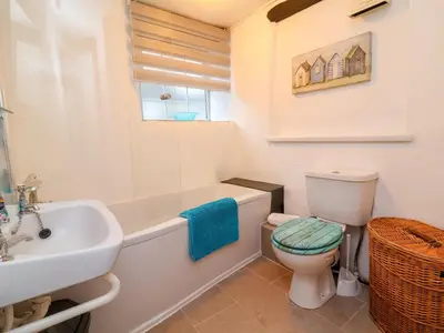 a bathroom with a toilet and a tub and a sink at Threshings Cottage in Tintagel