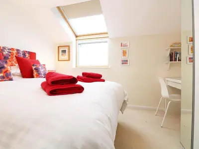 a bedroom with a bed with red towels on it at Chy Kerris, Carbis Bay in Carbis Bay
