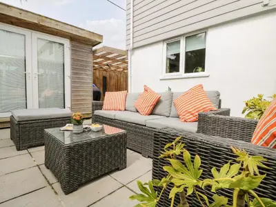 a patio with a couch and a table at Chy Kerris, Carbis Bay in Carbis Bay