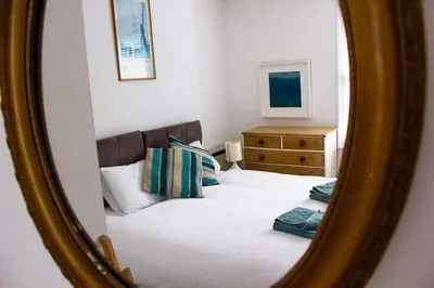 a mirror reflection of a bed in a bedroom at Drang house all rooms have stairs in Padstow