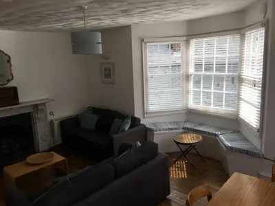 a living room with a couch and a table at Drang house all rooms have stairs in Padstow