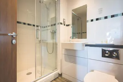 a bathroom with a shower and a toilet and a sink at County Arms in Truro