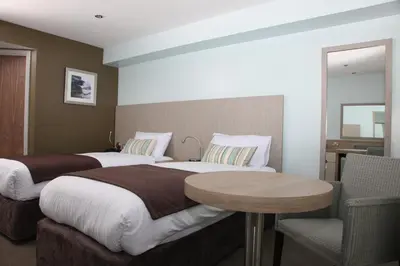 a hotel room with two beds and a table at County Arms in Truro