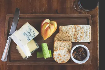 a wooden plate with different types of cheese and bread at County Arms in Truro