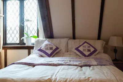 a bed with two pillows on it with a window at Demelza Cottage Apartment in Bodmin