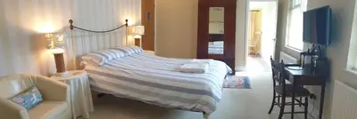 a bedroom with a bed and a desk and a chair at Polmarine in Polruan
