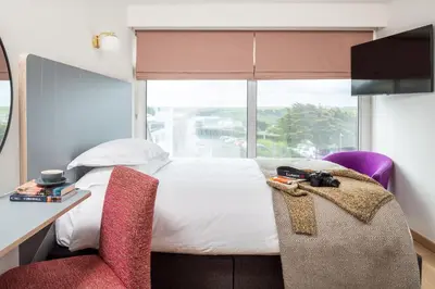 a bedroom with a bed and a desk and a window at Bedruthan Hotel & Spa in Newquay