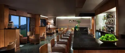 a bar in a restaurant with a bunch of chairs at Bedruthan Hotel & Spa in Newquay