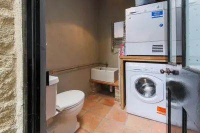a bathroom with a toilet and a washing machine at Fernleigh Cottage in Boscastle