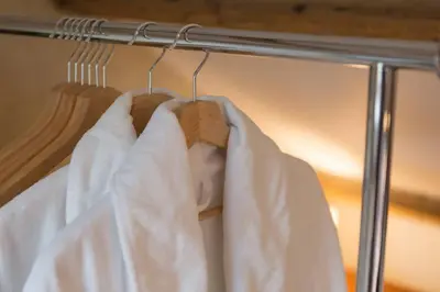 a rack with white shirts and a wooden hanger at Fernleigh Cottage in Boscastle