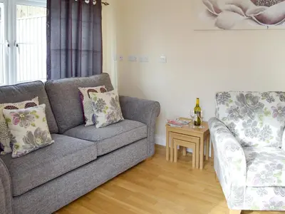 a living room with a couch and a chair at Lindum Leys in Saint Hilary