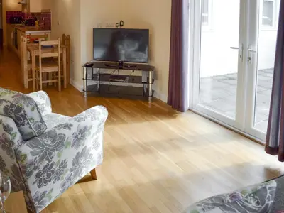 a living room with a couch and a television at Lindum Leys in Saint Hilary