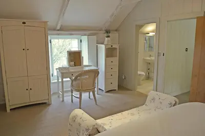 a bedroom with a desk and a table with a chair at Bonython Farmhouse in Cury