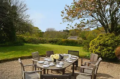 a wooden table with chairs and a tableasteryasteryasteryasteryasteryasteryasteryastery at Bonython Farmhouse in Cury