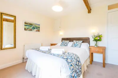 two beds in a room with a mirror at Cargurra Park Farm in Boscastle