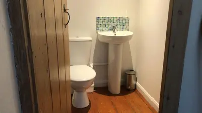 a bathroom with a toilet and a sink at The Old Farmhouse at Mena in Bodmin