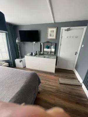 a bedroom with a bed and a mirror and a door at Skyline Guesthouse in Newquay