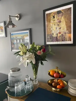 a vase with flowers and fruit on a table at Skyline Guesthouse in Newquay