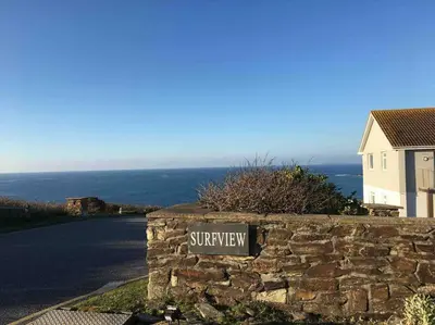 a stone wall with a street sign on a road at 34 Surfview Beach House in Newquay