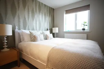 a bedroom with a large white bed with a window at Ocean Views 3 in Newquay