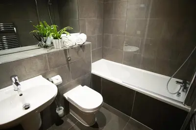 a bathroom with a sink and a toilet and a bath tub at Ocean Views 3 in Newquay