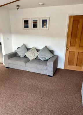 a couch with pillows sitting in a living room at The Haven in Portreath