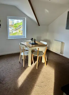 a table and chairs in a room with a window at The Haven in Portreath