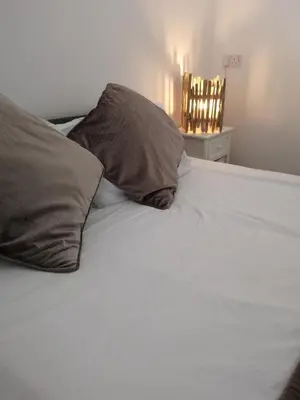 a white bed with two pillows on top of it at The Haven in Portreath