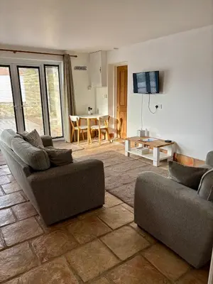a living room with two couches and a table at The Haven in Portreath