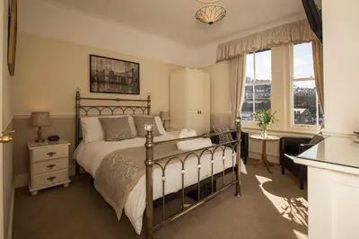 a bedroom with a bed and a large window at Deganwy Hotel in Looe