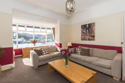 a living room with a couch and a table at Deganwy Hotel in Looe