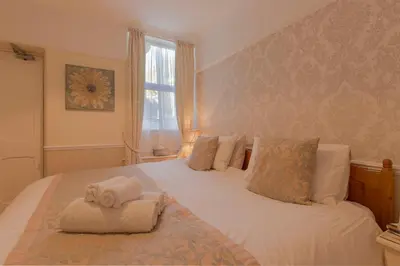 a bedroom with a bed with towels on it at Deganwy Hotel in Looe