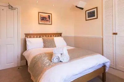 a bedroom with a bed with two towels on it at Deganwy Hotel in Looe