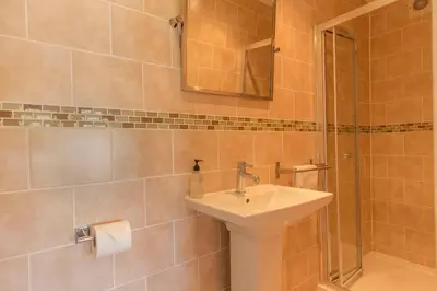 a bathroom with a sink and a shower at Deganwy Hotel in Looe
