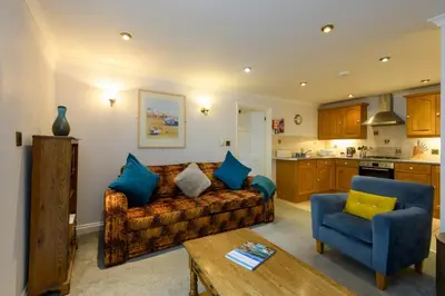 a living room with a couch and a table at Beachcombers Apartments in Newquay