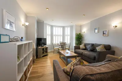 a living room with a couch and a table at Beachcombers Apartments in Newquay