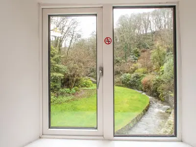 a window with a view of a stream at Mill Cottage in Tintagel