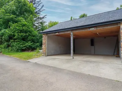 a garage with a large driveway at Cosy Cottage in Liskeard