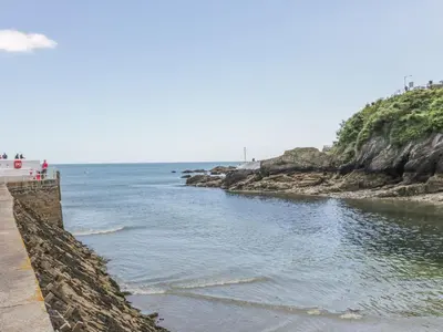 a retaining wall next to a body of water at Cosy Cottage in Liskeard