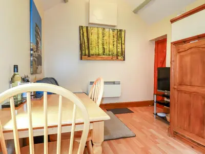 a dining room with a table and a television at Cosy Cottage in Liskeard